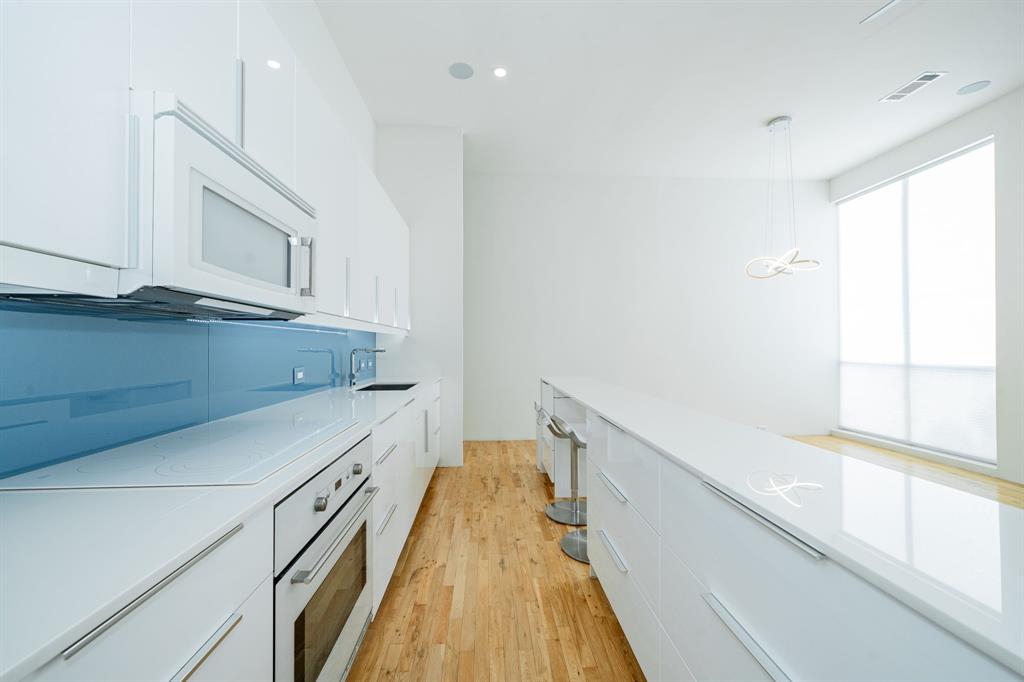 2325 Rusk Place Dallas, TX 75204 - Photo 7 of 27 a view of a kitchen with wooden floor and cabinets