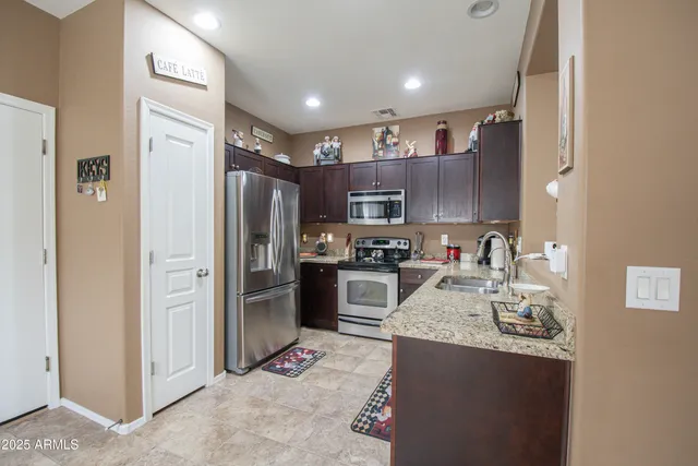 a kitchen with stainless steel appliances granite countertop a refrigerator stove and sink