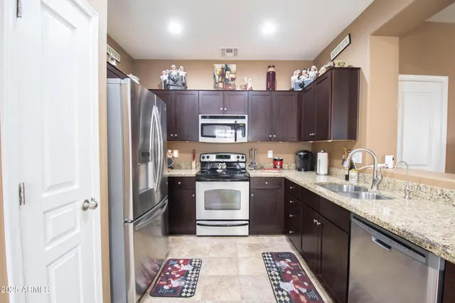 a kitchen with stainless steel appliances granite countertop a refrigerator and a sink