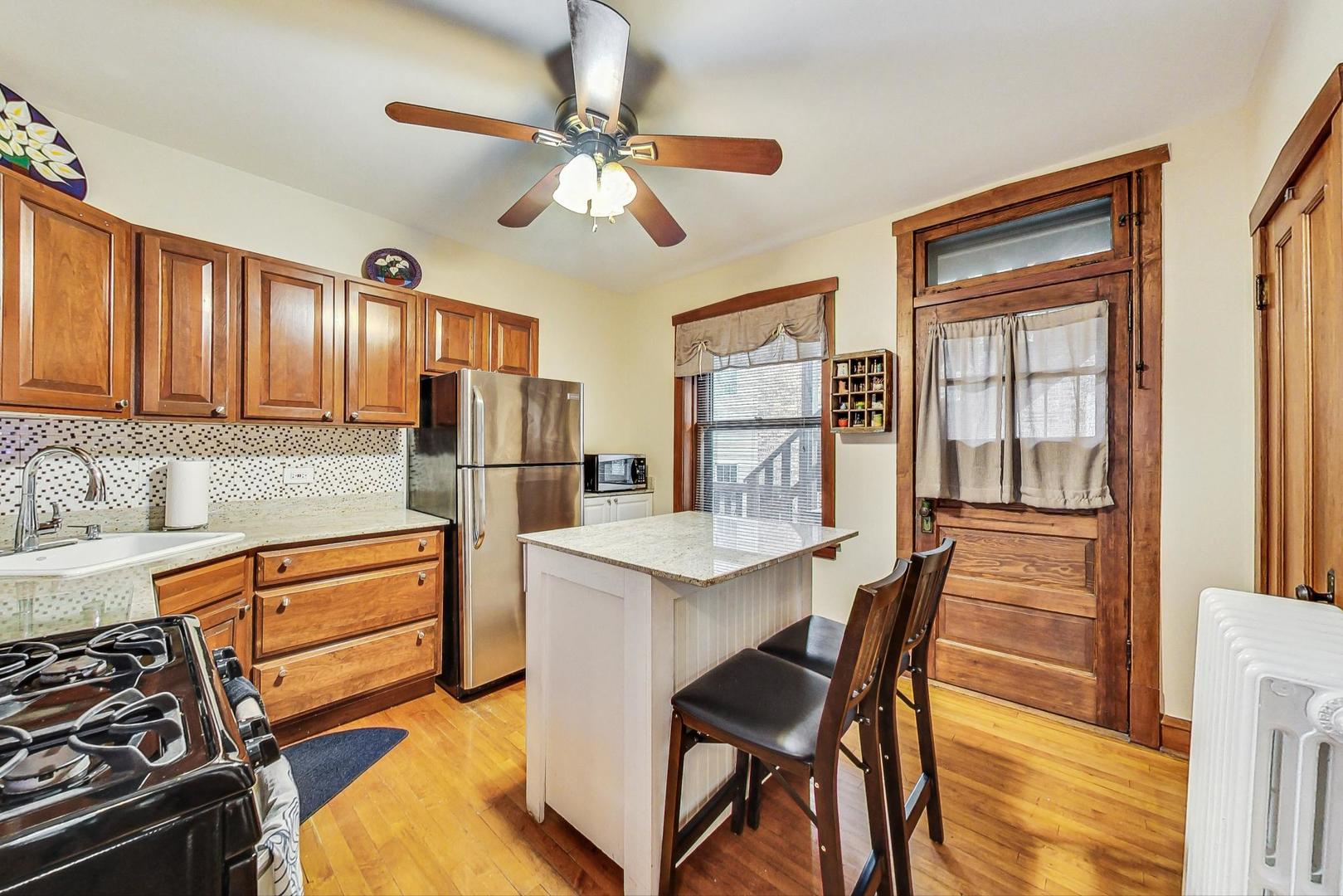 2004 West Walton Street, Unit 2B Chicago, IL 60622 - Photo 5 of 17 a kitchen with stainless steel appliances granite countertop a stove and a refrigerator