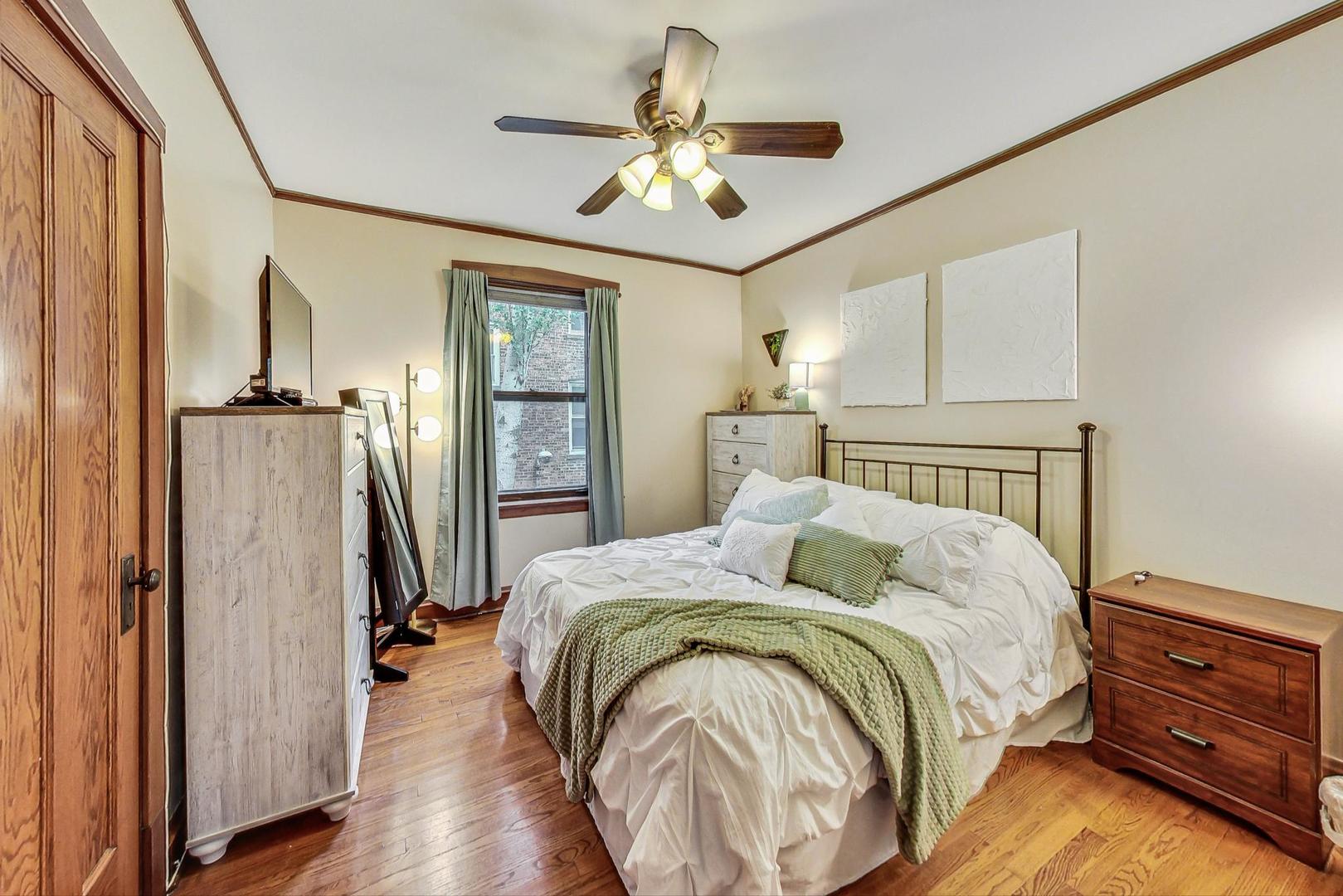 2004 West Walton Street, Unit 2B Chicago, IL 60622 - Photo 8 of 17 a bedroom with a bed and a chandelier