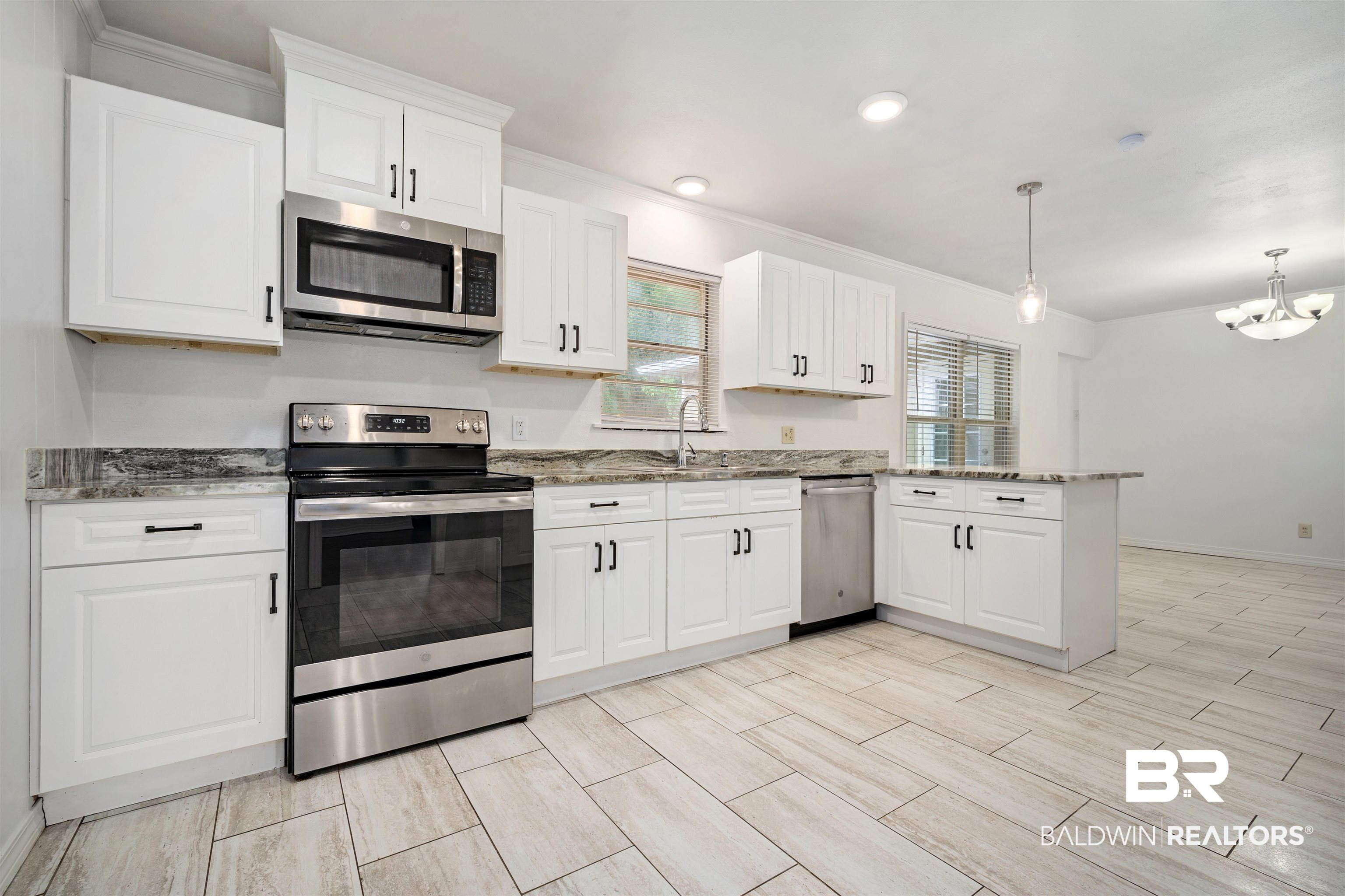 570 Markham Drive Mobile, AL 36609 - Photo 6 of 25 Kitchen featuring crown molding, a peninsula, light stone counters, and stainless steel appliances