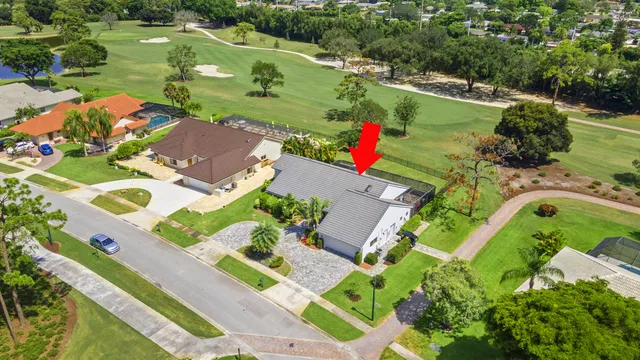 an aerial view of a house with a garden and lake view