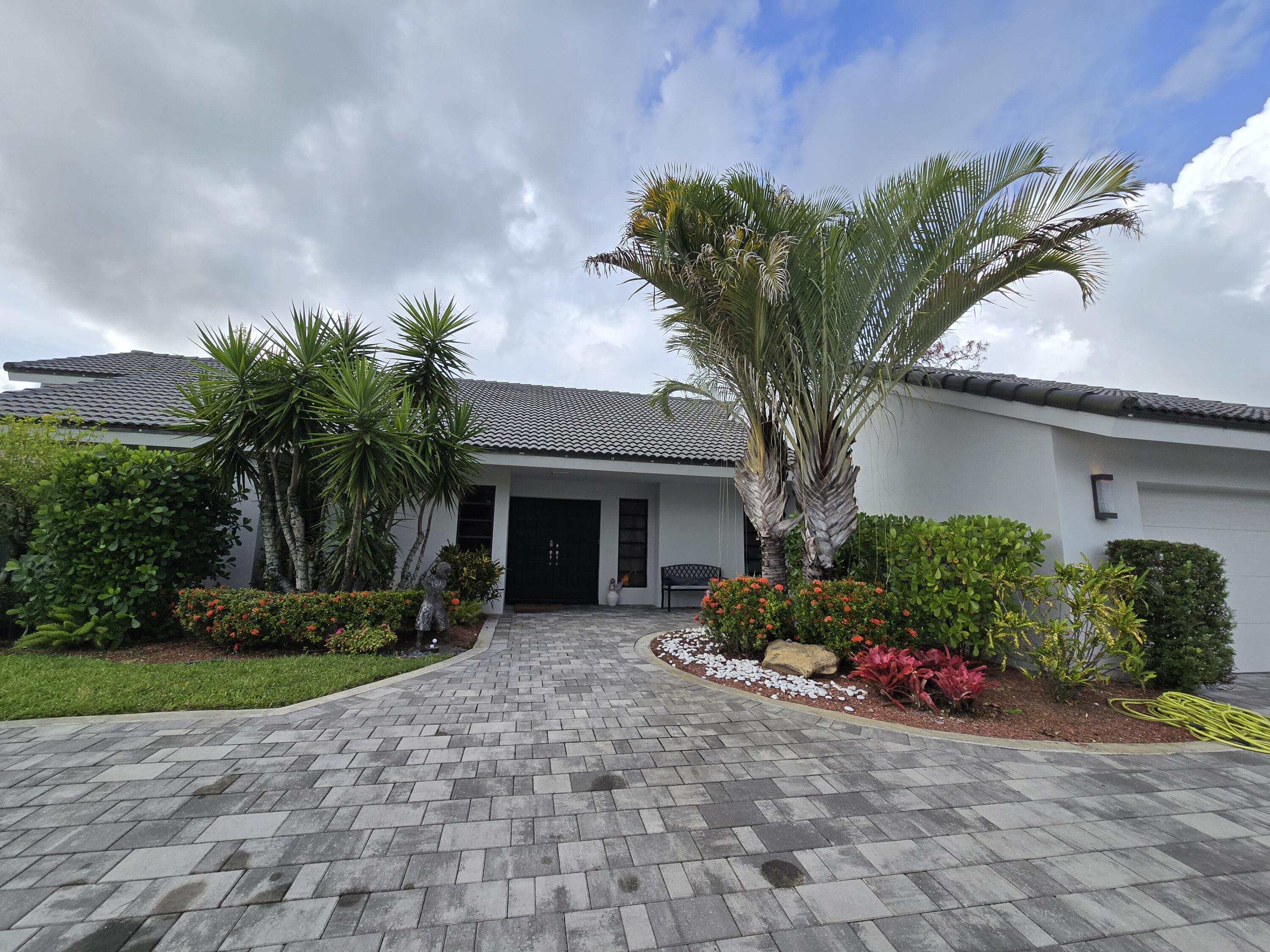 10718 Boca Woods Lane Boca Raton, FL 33428 - Photo 27 of 98 a front view of a house with garden