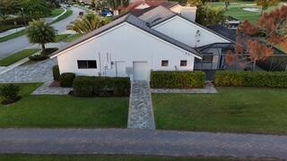 10718 Boca Woods Lane Boca Raton, FL 33428 - Photo 40 of 98 a view of a white house next to a yard and large trees