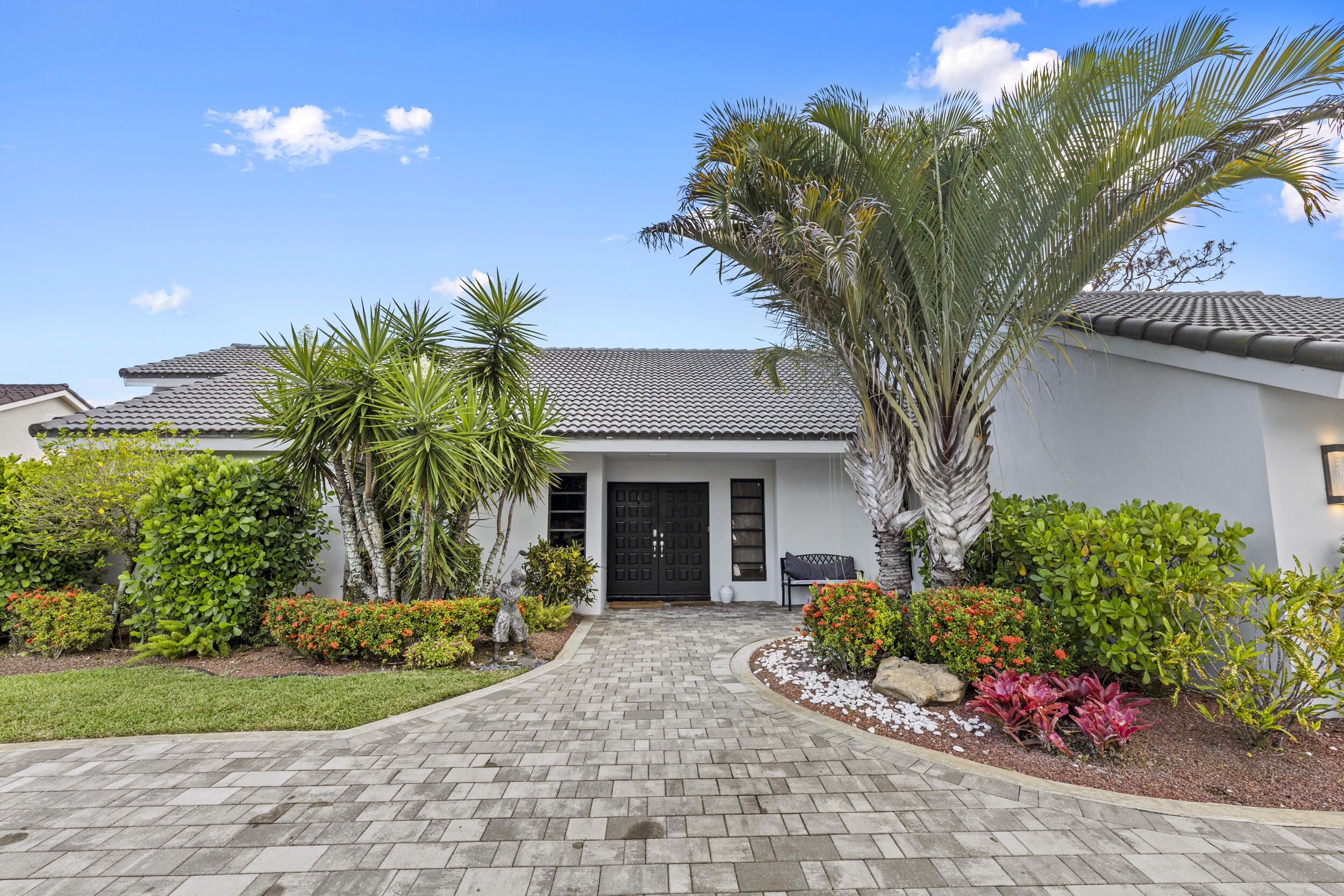 10718 Boca Woods Lane Boca Raton, FL 33428 - Photo 84 of 98 a front view of a house with a yard and potted plants