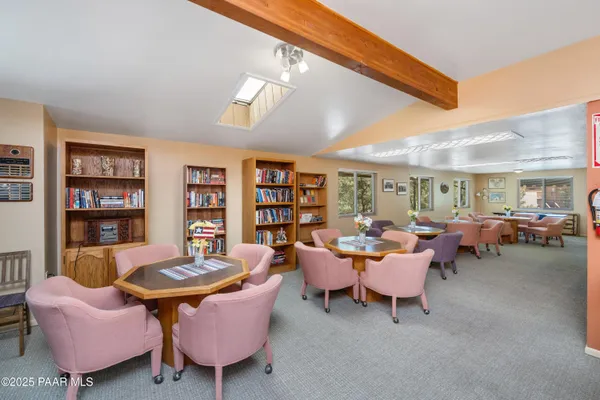 a living room with furniture a rug and a bookshelf