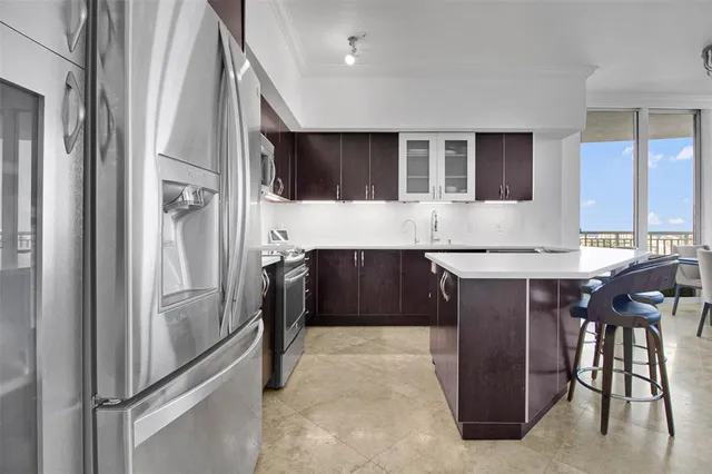 a kitchen with stainless steel appliances granite countertop a refrigerator and a stove top oven