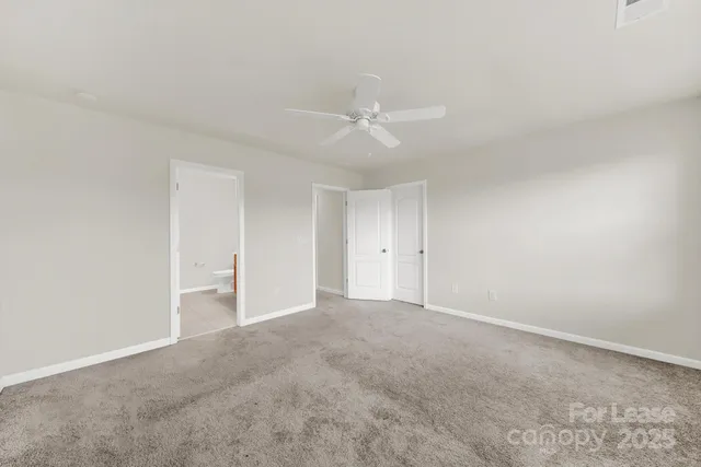 a view of an empty room with a ceiling fan
