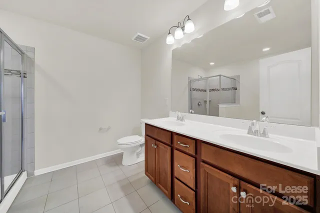 a bathroom with a double vanity sink toilet and a mirror