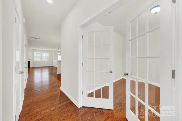 a view of a hallway with wooden floor