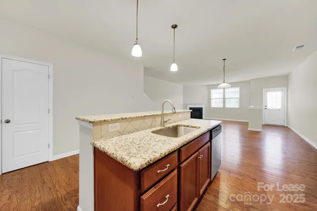 a kitchen with a sink a counter space and a wooden floor