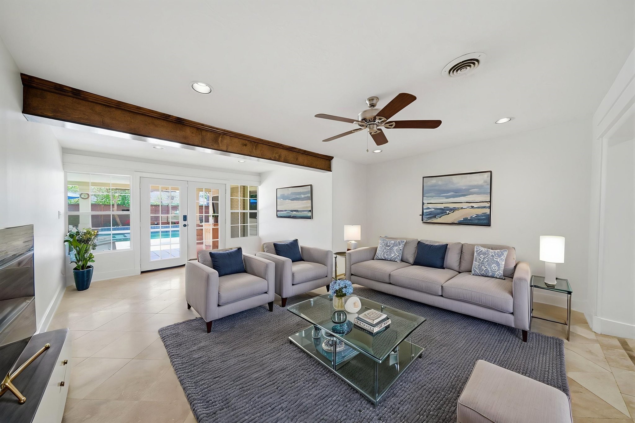 6427 Waltway Drive Houston, TX 77008 - Photo 13 of 37 *AI staged* Bright and inviting den featuring a ceiling fan, large windows, and French doors leading to a covered patio and pool. This spacious room is great for casual gatherings and a home office.