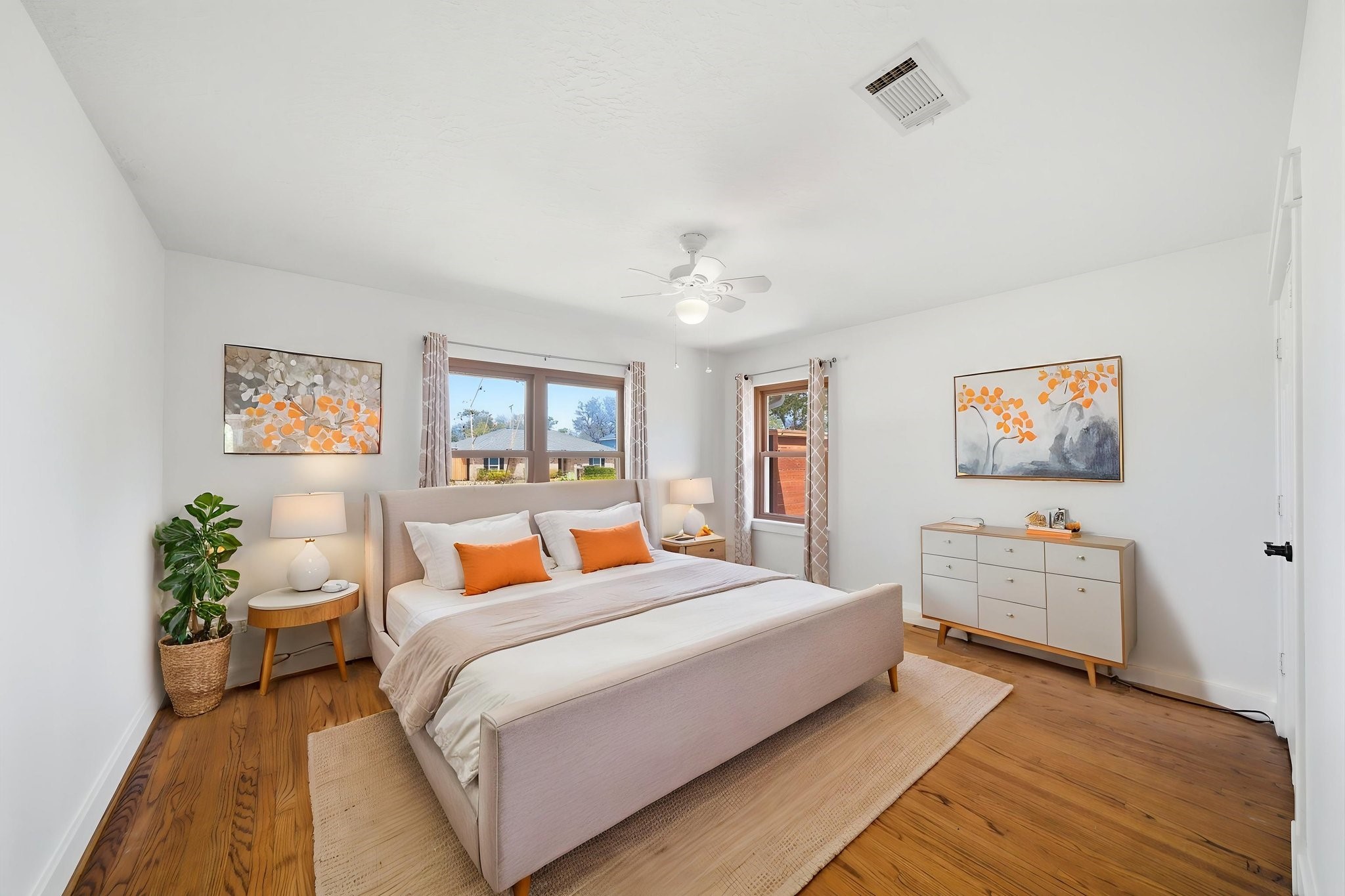 6427 Waltway Drive Houston, TX 77008 - Photo 31 of 37 *AI staging* This bright and airy front secondary bedroom features two windows, wood flooring, ceiling fan and double closet.