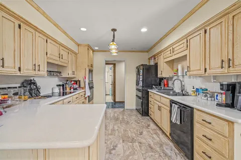 a large kitchen with stainless steel appliances granite countertop a lot of counter space and wooden floors