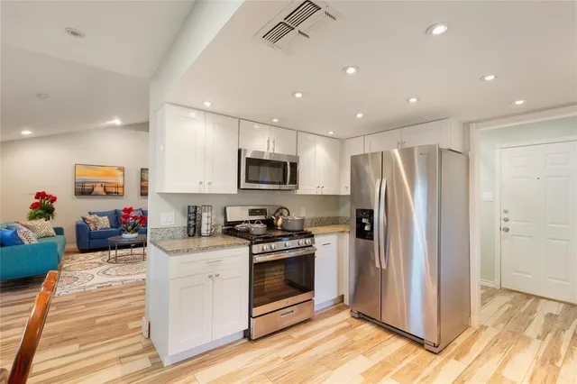 a kitchen with a sink stainless steel appliances and white cabinets