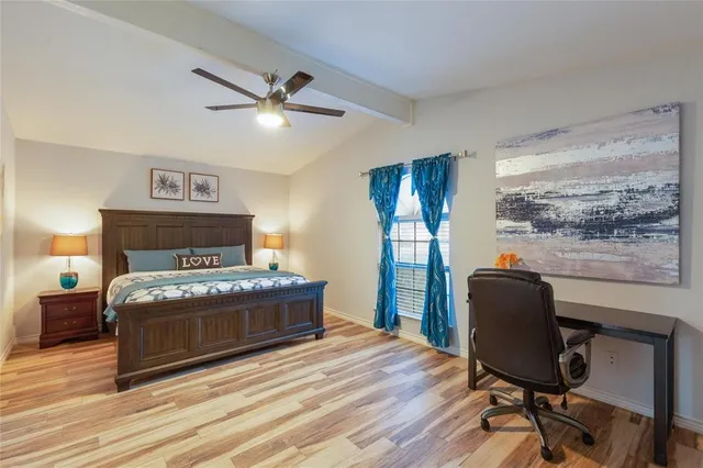 a bedroom with a bed and wooden floor