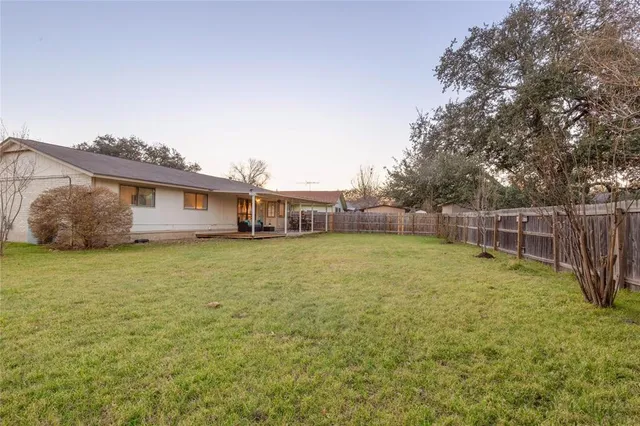 a view of a house with backyard and sitting area