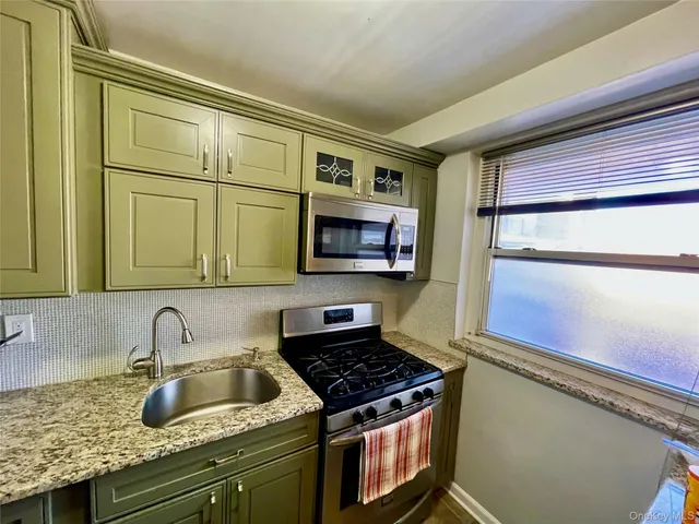 a kitchen with granite countertop a sink and a stove top oven