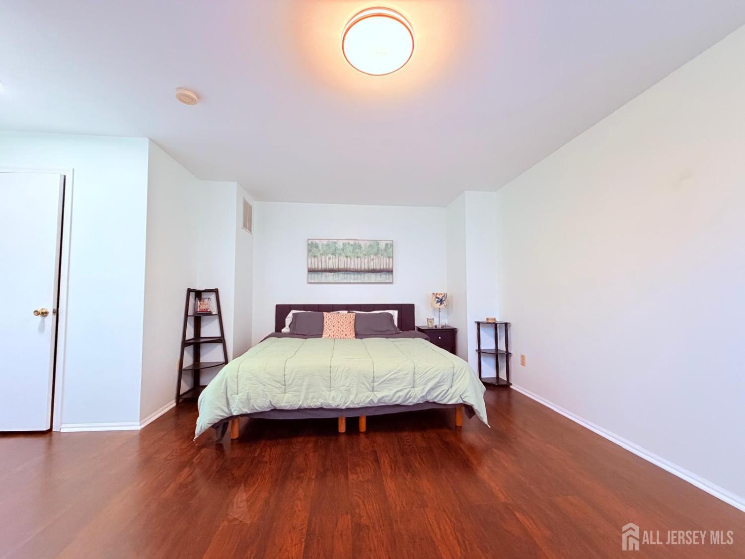 918 Plymouth Road North Brunswick, NJ 08902 - Photo 15 of 30 a bedroom with a bed and wooden floor