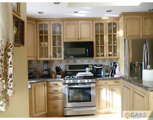 435 Crows Mill Road Fords, NJ 08863 - Photo 12 of 24 a kitchen with stainless steel appliances granite countertop a stove a sink and a microwave