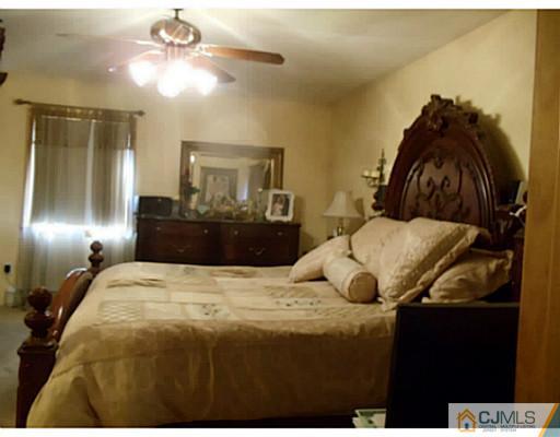 435 Crows Mill Road Fords, NJ 08863 - Photo 14 of 24 a bedroom with a bed and a chandelier