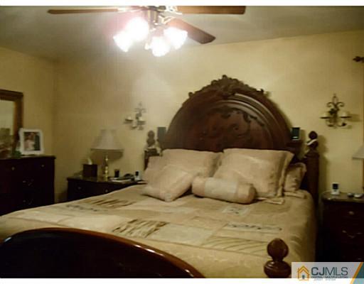 435 Crows Mill Road Fords, NJ 08863 - Photo 22 of 24 a bedroom with a bed and a chandelier