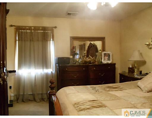 435 Crows Mill Road Fords, NJ 08863 - Photo 23 of 24 a bedroom with a bed and a mirror
