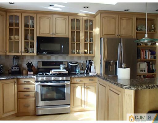 435 Crows Mill Road Fords, NJ 08863 - Photo 9 of 24 a kitchen with stainless steel appliances granite countertop a stove a sink and a microwave