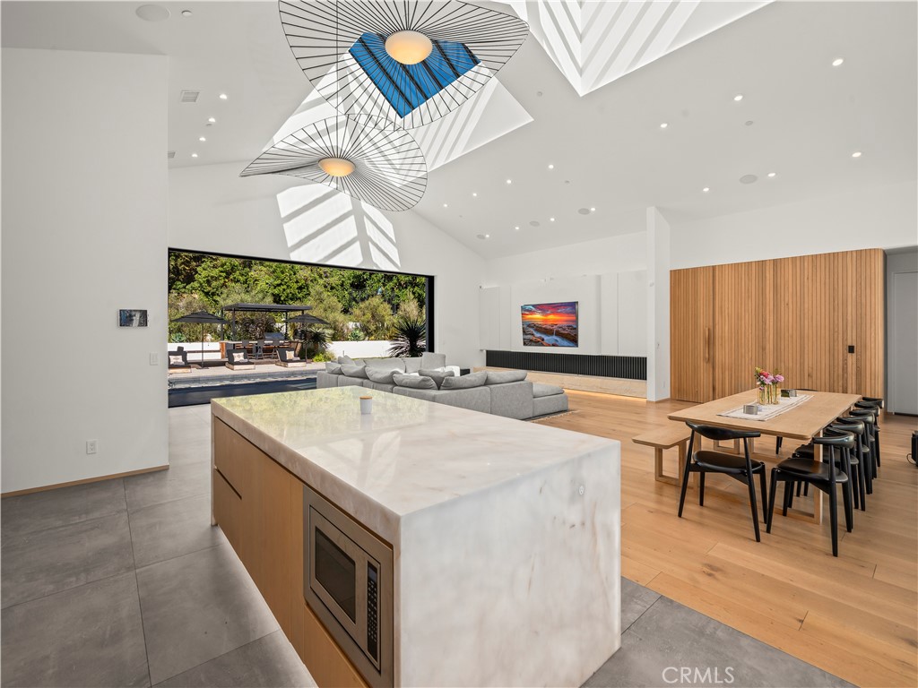 4874 Sun Valley Road Del Mar, CA 92014 - Photo 9 of 15 a kitchen with stainless steel appliances kitchen island granite countertop a table and chairs in it