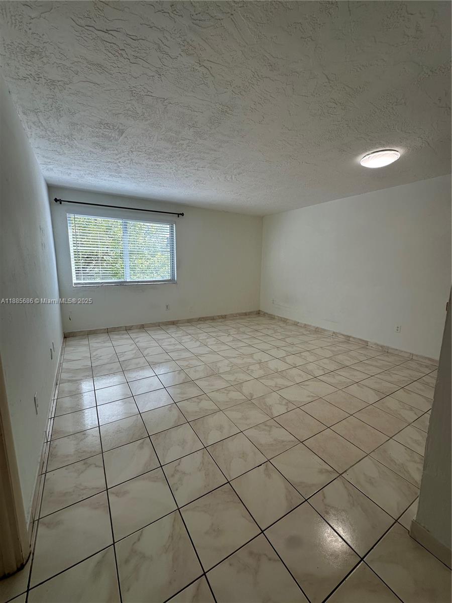 5505 Northwest 7th Street, Unit W219 Miami, FL 33126 - Photo 4 of 9 an empty room with windows
