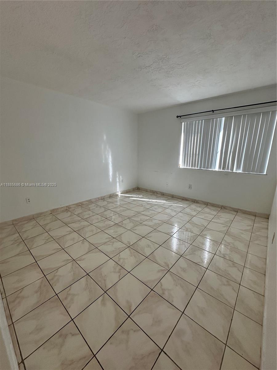 5505 Northwest 7th Street, Unit W219 Miami, FL 33126 - Photo 6 of 9 a view of an empty room and staircase