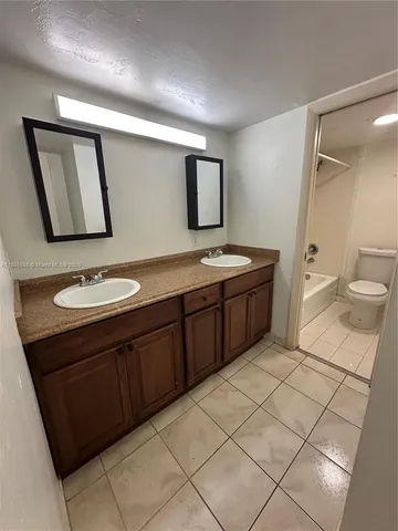 a bathroom with a sink a toilet and mirror
