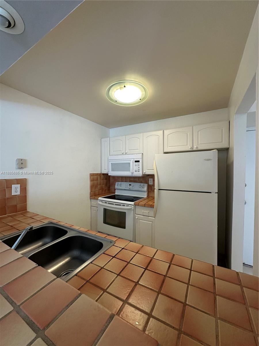 5505 Northwest 7th Street, Unit W219 Miami, FL 33126 - Photo 9 of 9 a kitchen with a stove a refrigerator and a stove