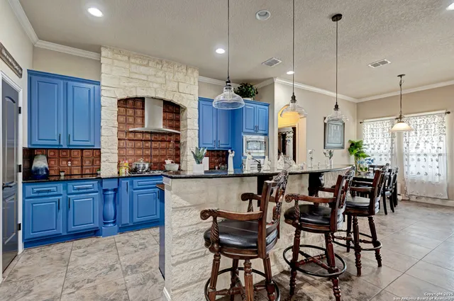 a kitchen with granite countertop a table chairs stove microwave and cabinets
