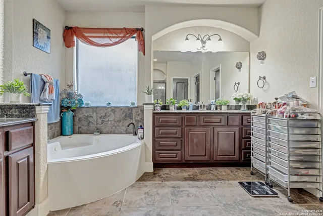 a bathroom with a tub a double vanity sink and a mirror
