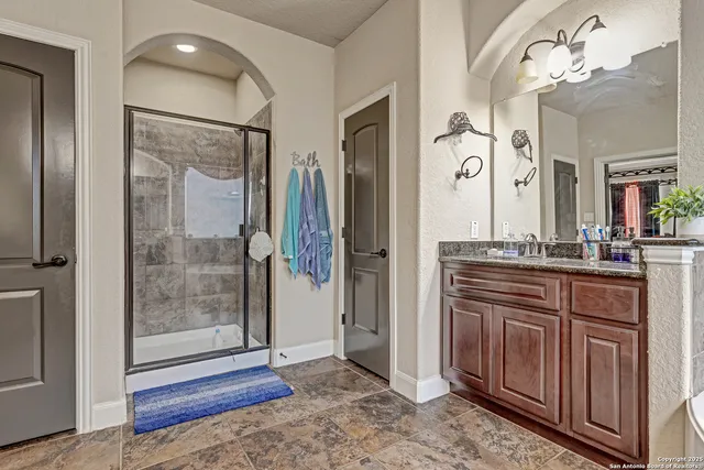 a spacious bathroom with a granite countertop sink mirror and shower