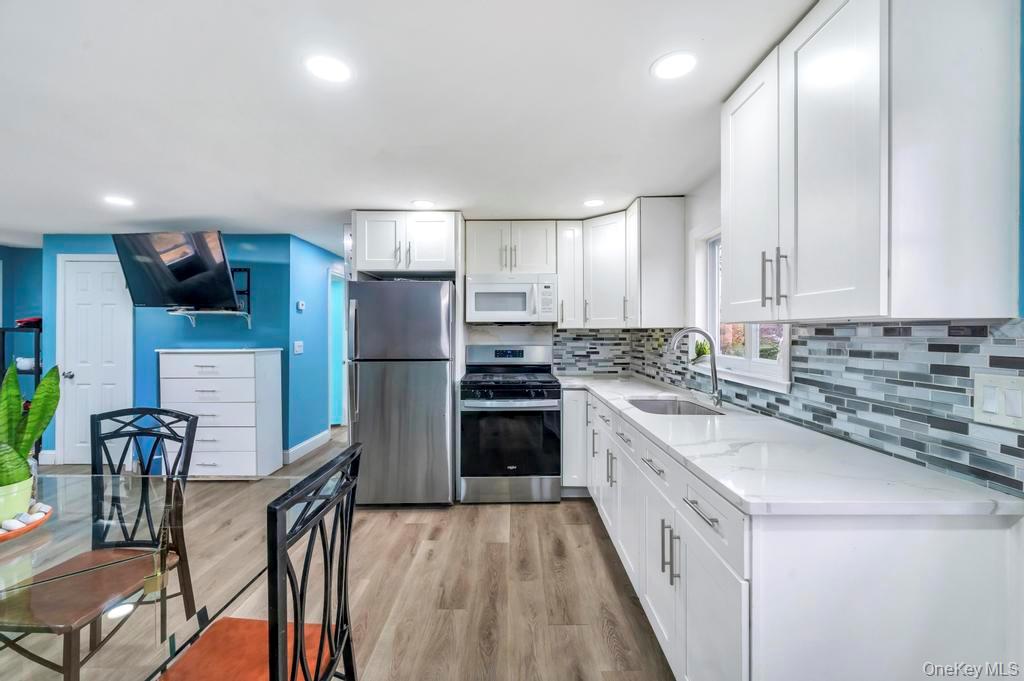 19 Windus Road Shirley, NY 11967 - Photo 11 of 29 a kitchen with stainless steel appliances granite countertop a refrigerator sink and cabinets