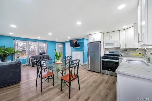 a view of kitchen with refrigerator stove dining table and chairs