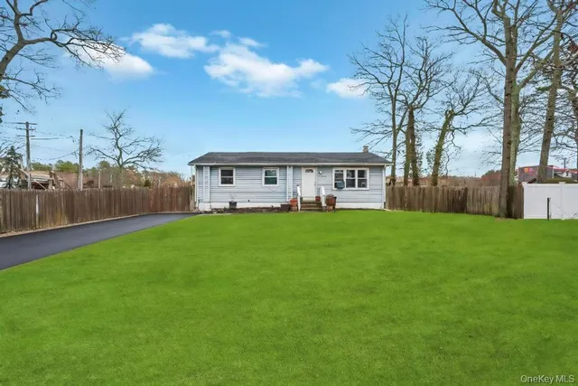a view of a house with a big yard and large trees