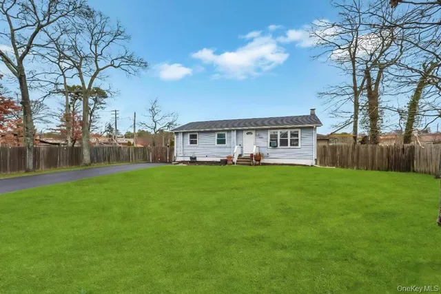 a view of a house with backyard and a tree