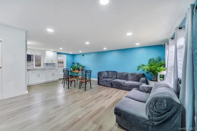 a living room with furniture and a dining table with kitchen view