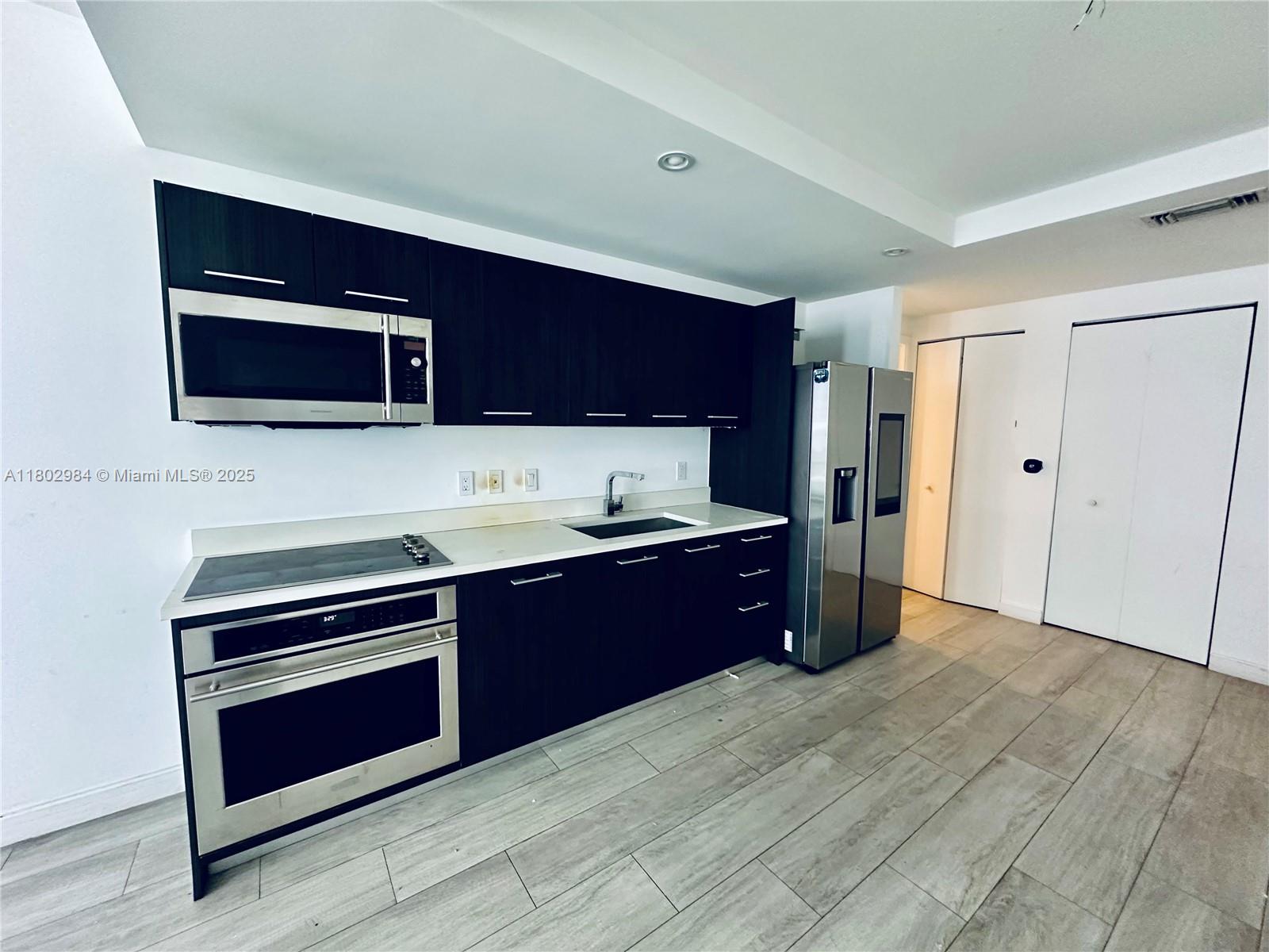 55 Southwest 9th Street, Unit 3409 Miami, FL 33130 - Photo 2 of 28 a kitchen with stainless steel appliances granite countertop a stove microwave and refrigerator