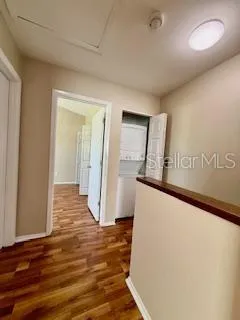 a view of a livingroom with wooden floor and staircase