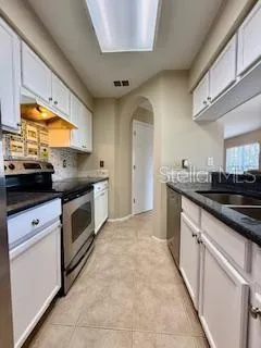 a kitchen with stainless steel appliances granite countertop a sink and cabinets