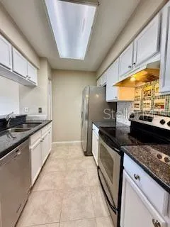 a large kitchen with stainless steel appliances granite countertop a stove and a sink