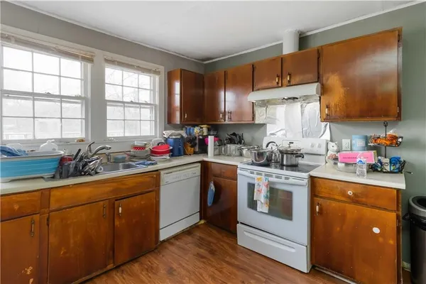 a kitchen with kitchen island granite countertop a sink cabinets and stainless steel appliances