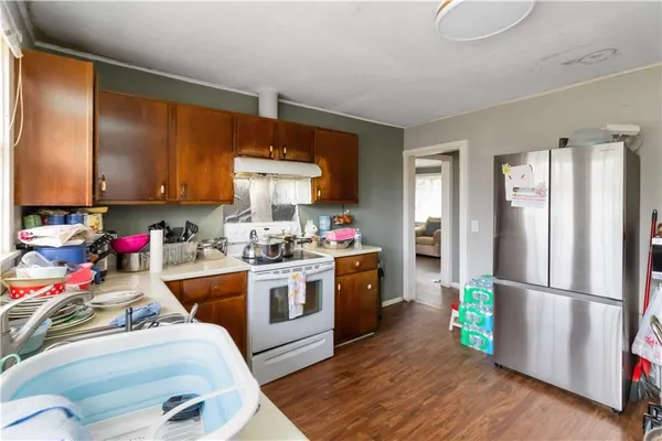 a kitchen with a refrigerator wooden floor and sink