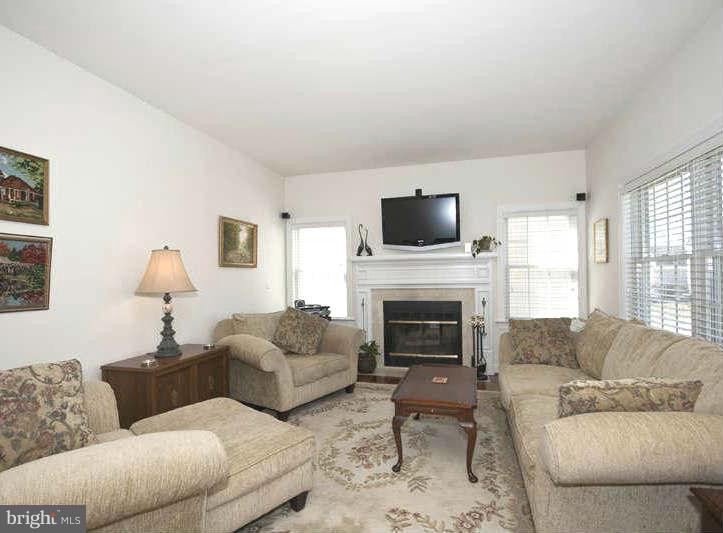 9118 Cuckold Point Road Baltimore, MD 21219 - Photo 3 of 27 a living room with furniture a fireplace and a flat screen tv