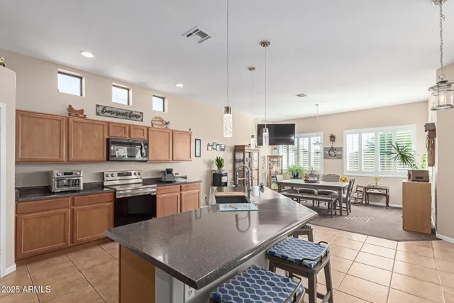 a kitchen with stainless steel appliances kitchen island granite countertop a sink and cabinets